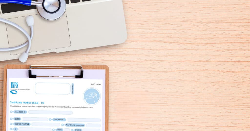 Stethoscope and blue pen atop a laptop with a clipboard holding a medical certificate on a wooden desk.